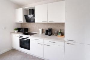 a white kitchen with white cabinets and appliances at Heide-deluxe in Soltau