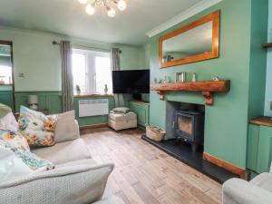 a living room with a fireplace and a television at 2 Rock View in Settle
