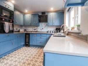 a blue kitchen with a sink and blue cabinets at 2 Rock View in Settle