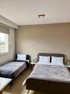 a bedroom with two beds and a window at Alpha Apartments 42 in Serres