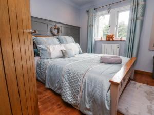 a bedroom with a large bed and a window at 2 Rock View in Settle