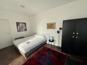 a bedroom with a white bed and a red rug at Ai Priori in Gemona del Friuli