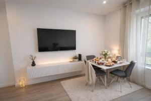 a dining room with a table with chairs and a tv at Heide-deluxe in Soltau