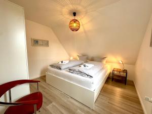 a bedroom with a white bed in a attic at Inselglück Föhr in Wrixum