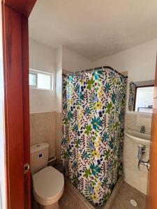 a bathroom with a shower curtain with a toilet at Hostal El Recreo in Barranquilla +32 photos