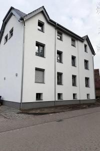 a white building with black windows on a street at Heide-deluxe in Soltau