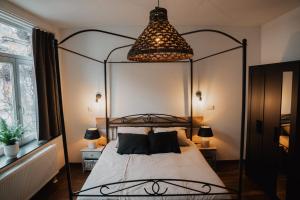 a bedroom with a metal canopy bed with a chandelier at Cé La Vie in Maaseik
