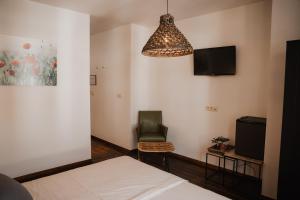 a bedroom with a bed and a chair and a tv at Cé La Vie in Maaseik