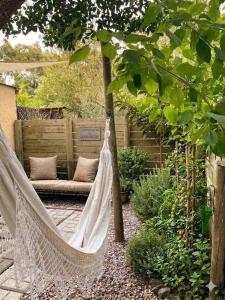 a hammock hanging from a tree in a garden at Refugio El Dormilón, Jardín cercado, Wifi, Playa 300 m, Pet friendly in La Pedrera