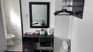 a bathroom with a black desk and a mirror at Boomerang Blackpool in Blackpool