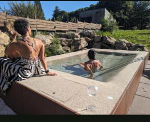 a woman and a child in a swimming pool at Bungalow TRADICIONS en FincaReal in Negreira
