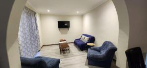 a living room with two blue chairs and a tv at House Magriet in Doring Bay