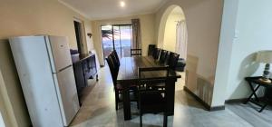 a dining room with a table and a refrigerator at House Magriet in Doring Bay