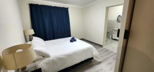 a bedroom with a bed and a blue curtain at House Magriet in Doring Bay