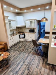 a large kitchen with white cabinets and a table at Robert's Apartment in Celje