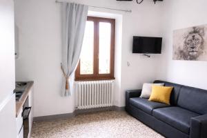 a living room with a couch and a window at 2ª Casa del Borgo Antico in Poggibonsi