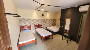 a small room with two beds and a mirror at Hostel-Casa25-Meaipe in Guarapari
