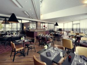 a dining room with tables and chairs and a restaurant at Mercure Orange Centre A7/A9 in Orange
