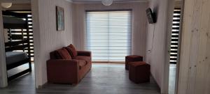 a living room with a brown chair and a bed at Aegla lodge in Pichilemu