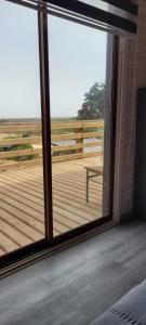 a sliding glass door with a view of a deck at Aegla lodge in Pichilemu