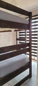 two bunk beds in a room with a window at Aegla lodge in Pichilemu