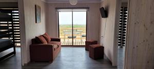 a living room with a couch and a window with a view at Aegla lodge in Pichilemu +52 photos
