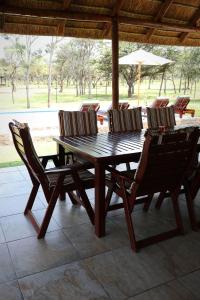 a wooden table and chairs on a patio at Hemel Bushveld Lodge in Vaalwater +39 photos