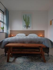 a bedroom with a large bed with a wooden headboard at De Allerhof in Hattem