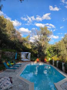a swimming pool with two chairs and a table at La licorne in Serriera