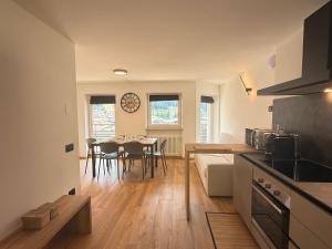 a kitchen and living room with a table and chairs at Al Piz - Dimora Alpina in Pellizzano
