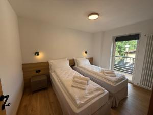 two beds in a room with a window at Al Piz - Dimora Alpina in Pellizzano