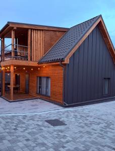 a house with a gambrel roof with a patio at Stone & Soul House in Chernihiv