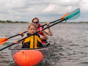 a woman and a child in a boat on the water at DCU-Camping Grønninghoved Strand in Sjølund