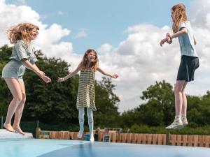 two girls jumping on top of a trampoline at DCU-Camping Grønninghoved Strand in Sjølund