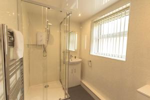 a bathroom with a glass shower and a sink at Tregurrian Villas in Newquay +23 photos