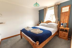 a bedroom with a bed with towels on it at Tregurrian Villas in Newquay