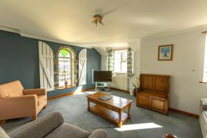 a living room with a couch and a table at Tregurrian Villas in Newquay