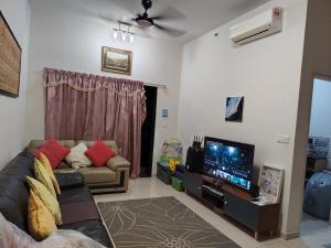 a living room with a couch and a flat screen tv at Habitus in Shah Alam