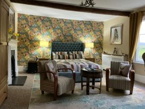 a bedroom with a bed and a couch and chairs at Rorrington Hall in Chirbury