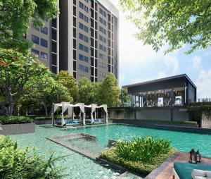 a swimming pool with umbrellas and a building at Habitus in Shah Alam