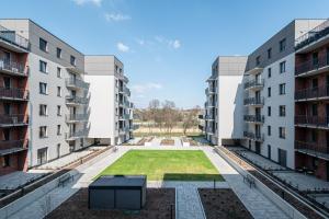 a courtyard in an apartment building with a lawn between two buildings at Tarasy Bernardyńskie 44 in Kalisz