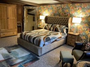a bedroom with a large bed and a chair at Rorrington Hall in Chirbury