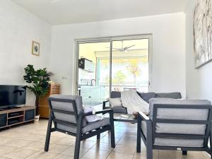 a living room with two chairs and a couch at Grain de Corail in Saint-François