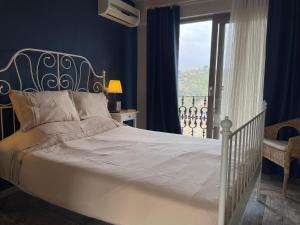 a bedroom with a white bed and a balcony at Ayda Bağları Winery & Vineyards in Seferihisar +25 photos