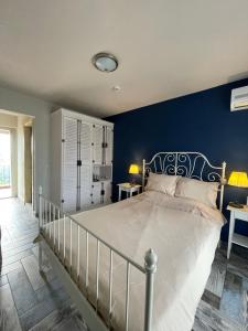 a bedroom with a large bed with a blue wall at Ayda Bağları Winery & Vineyards in Seferihisar