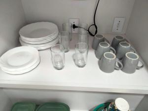 a white shelf with plates and glasses on it at Casa Cordelia Mangaratiba Centro in Mangaratiba +18 photos