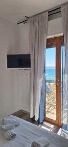 a bedroom with a bed and a view of the ocean at La Risacca in Pietra Ligure
