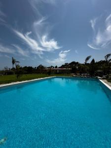 a large blue swimming pool under a cloudy sky at Club Positano Fundo Dell'Angelo in Mala