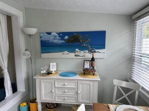 a white dresser in a room with a picture on the wall at Sunny PaG Island rental wbikes-just steps2beach in St. Pete Beach