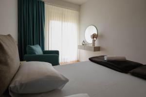 a bedroom with a bed and a chair and a mirror at Adria Gold - Bayview - Luxury in Kotor
